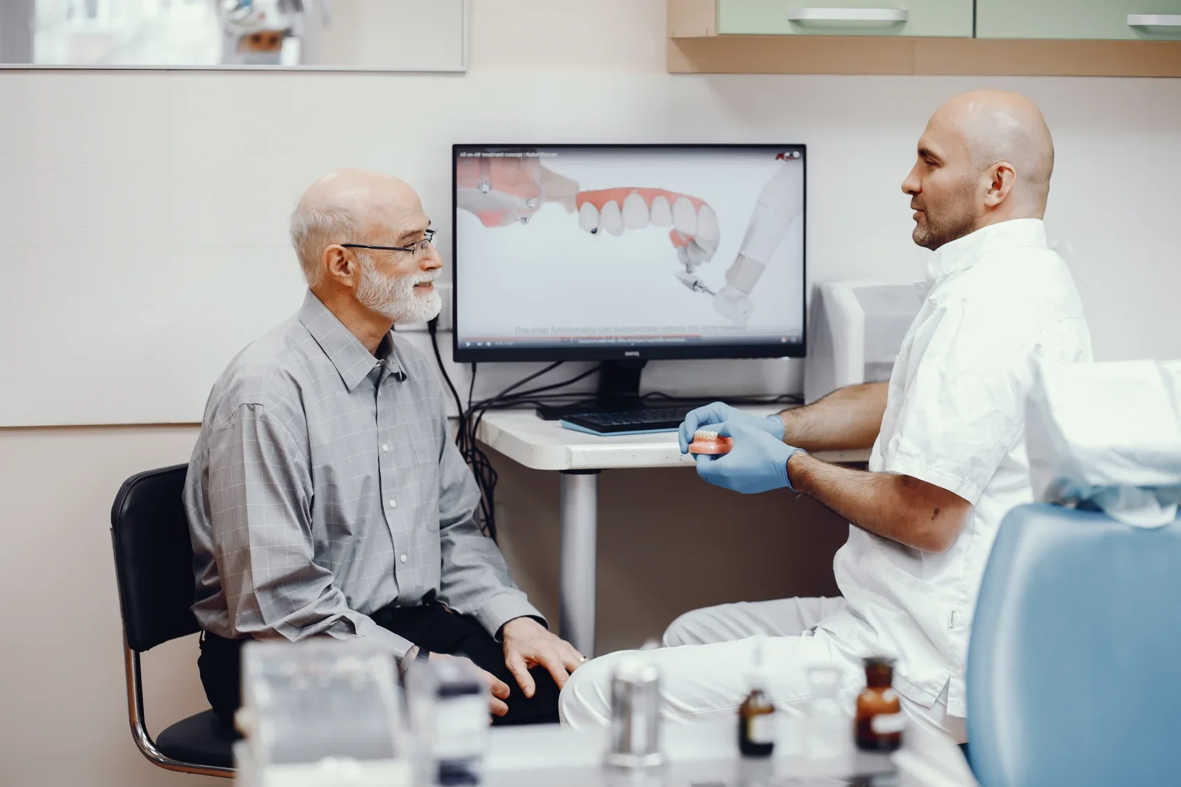 Dr. Smith going through a treatment plan and its cost on screen with a patient