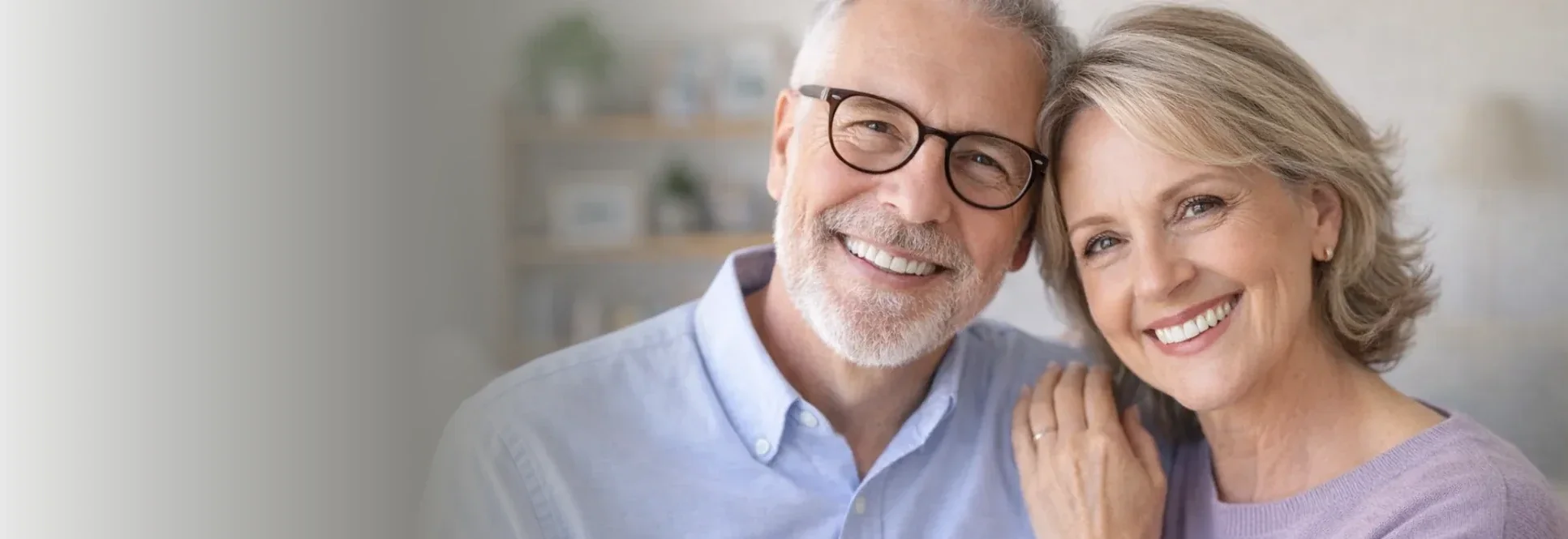 A mature couple smiling after full mouth restoration treatment